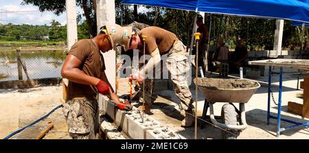 Phước Hòa, Vietnam (26. Juli 2022) Bauelektriker 3. Klasse Gaoa Mauga (links) und Baumeister 2. Klasse Grant Templeton (rechts), mit Naval Mobile Construction Battalion (NMCB) 4, legen den ersten von 15 Kursen des Blocks für Betonmauerwerk (CMU) für das Projekt der Phước Hòa Grundschule in Vietnam. NMCB-4 hat sich mit Marines des 7. Engineer Support Battalion (ESB) zusammengetan, um der vietnamesischen Provinz Phú Yên im Rahmen der Pacific Partnership 22 ein brandneues Schulhaus mit zwei Räumen zur Verfügung zu stellen. NMCB-4 wird in der gesamten Region Indo-Pacific und den Territorien der Vereinigten Staaten zur Unterstützung von und Mai eingesetzt Stockfoto