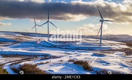 Windturbinen auf einem schneebedeckten Hügel in Wales (Bryn Bach) aus der Vogelperspektive Stockfoto