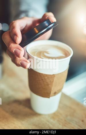 Das sieht nach einer perfekten Mischung aus. Nahaufnahme eines unbekannten Baristas, der eine Tasse frisch gebrühten Kaffees in einem Café schließt. Stockfoto