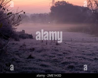 Sonnenaufgang an einem kalten und frostigen Morgen mit tiefliegendem Nebel über den Feldern von East Cheshire Stockfoto