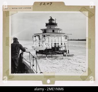 Big Freeze auf dem Potomac. Die Küstenwache Cutter MADRONA nasselt in der Nähe des Mathias Point Lighthouse im Potomac, während sich ein Mitglied der Stationscrew in ein kleines Boot senkt, um an Bord zu kommen. Diese Leistung wiederholte sich in zahlreichen Fällen, als Lichtwächter auf dem Potomac wegen der über zwei Wochen andauernden schweren Eisbedingungen evakuiert wurden. Stockfoto