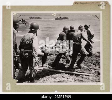 Die Küstenwache führt Verwundete auf den Philippinen aus. Küstenwachmänner eines Invasionstransports entfernen ein Opfer der Armee vom brennenden Strand von Leyte Island auf dem Höhepunkt des Befreiungsschlags auf die Philippinen. Aus einem bemannten Transport der Küstenwache ziehen diese erfahrenen Eindringlinge die Truppen in Landungsschiffe und gehen mit den Verwundeten zurück. Stockfoto