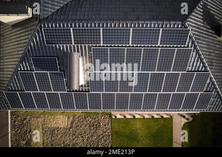 Wohnhaus mit Solarpaneelsystem auf dem Dach. Gebäudedach mit Solarmodulen zur Stromerzeugung durch Photovoltaik. Konzept für nachhaltige Ressourcen. Stockfoto