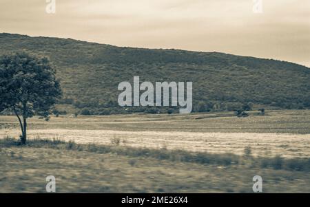 Natürliche Landschaft Berge Hügel und landwirtschaftliche Flächen während der Fahrt in Kroatien. Stockfoto