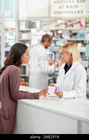 Wellness, Gesundheit und zufriedener Apothekenkunde an der Ladentheke für medizinische Expertise mit Lächeln. Pharmazeutische Beratung und Stellungnahme von Apothekerinnen Stockfoto