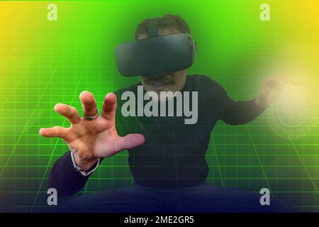 Der junge Mann benutzt einen Virtual-Reality-Betrachter. Modernes Porträt mit trendy Optik und leuchtenden Farben. Stockfoto