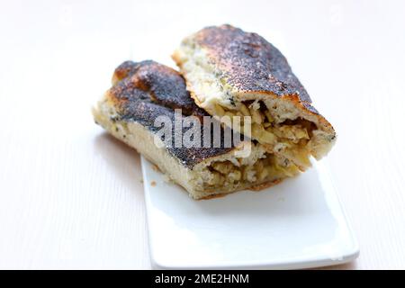 Strudel mit Äpfeln mit Mohnsamen auf weißem, flachem Teller und hellem Hintergrund Keine anderen Zutaten sauberer Platz für Ihren Text köstliches Essen Kochen hausgemachte Backprodukte gesunde Lebensmittel Stockfoto