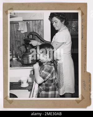 Sheila Woodward, Tochter von Chief Boatswain's Mate George Woodward, putzt sich morgens die Zähne, während ihre Mutter Wasser im Owl's Head Lighthouse in Maine pumpt. Die Familie spielt eine wichtige Rolle bei der Instandhaltung des Leuchtturms, der Schiffe entlang der Küste führt. Stockfoto