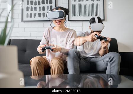 VR, Gaming und Metaversum mit einem Paar, das zusammen zu Hause Videospiele spielt, um Spaß zu haben oder Spaß zu haben. Virtuelle Realität, Spiel und 3D ai mit einem Mann und Stockfoto