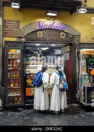 Zwei Nonnen in weißen Bademänteln und schwarzen Gewohnheiten stehen vor der Sinduco Gelateria in Neapel, Italien. Stockfoto