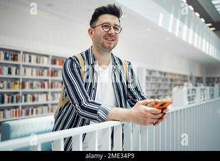 Bibliothek, intelligenter Student oder intelligenter Mann mit forschungszielen für doktortitel, Erfolgsvision und Begeisterung für Wissen. Universität, Campus oder Stockfoto