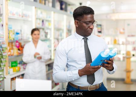 Mann hält Flasche mit Haarpflegeprodukt Stockfoto