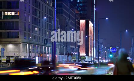 Warschau, Polen. 23. November 2022 Abendliches Stadtleben im Zentrum von Warschau. Autos auf der Straße. Straßenlaternen in der Stadt bei Nacht. Stockfoto