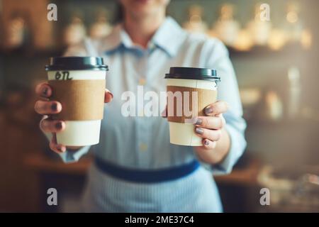 Dann kümmere dich um deinen Kaffee. Nahaufnahme eines unbekannten Baristas, der Tassen Kaffee in einem Café hält. Stockfoto