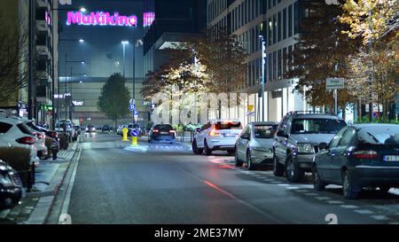 Warschau, Polen. 23. November 2022 Abendliches Stadtleben im Zentrum von Warschau. Autos auf der Straße. Straßenlaternen in der Stadt bei Nacht. Stockfoto