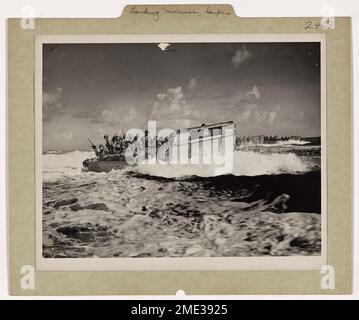 Die Küstenwache landet die Marines in Saipan. Mit dem Schild der Küstenwache auf der stumpfen Nase und den Küstenwachmännern an der Kontrolle, liegt ein Marine-gepacktes LCVP am Strand von Saipan, dem japanischen Stützpunkt weniger als 1.500 Meilen von Tokio entfernt. Die Marines halten ihre Finger hoch mit dem „V for Victory“-Schild. Sie gewannen ihren Sieg nach dem erbitterten Widerstand des Feindes, der in den ersten zwei Wochen der Invasion fast 10.000 amerikanische Opfer kostete. Stockfoto