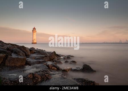 New Brighton, Großbritannien: Leuchtturm von Perch Rock bei Sonnenaufgang, lange Exposition bei Ebbe und Flut. Stockfoto