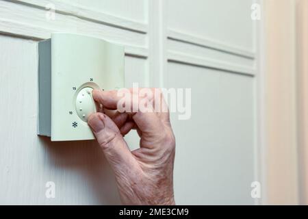 Reife Frau stellt die Zentralheizung zu Hause ab, um Geld zu sparen Stockfoto