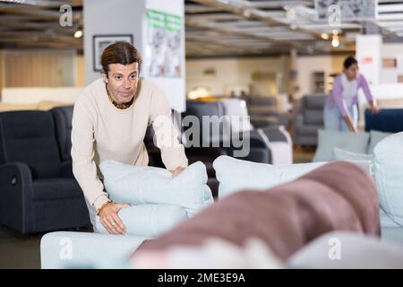 Der Mann überprüft die hohe Qualität des Sofas Stockfoto