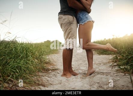 Diese Zehenlockenküsse... ein junges Paar, das einen romantischen Tag am Strand verbringt. Stockfoto