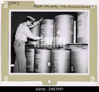 Ein Küstenwächter inspiziert die Lagerung gefährlicher Fracht im Hafen von Philadelphia. Diese Rolle ist Teil der Bemühungen der Küstenwache, die sichere Handhabung und Lagerung von Gefahrstoffen in US-Häfen zu gewährleisten. Stockfoto