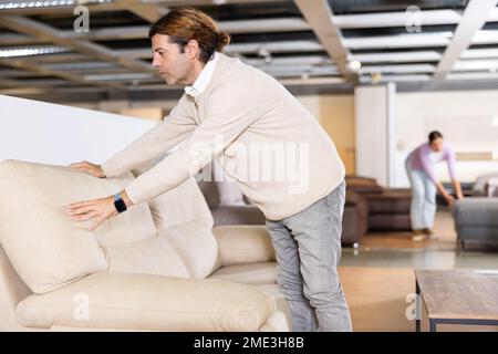 Der Mann überprüft die hohe Qualität des Sofas Stockfoto