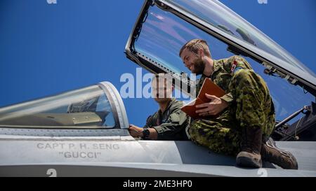 MARINE CORPS BASIS HAWAII, Hawaii (27. Juli 2022) USA Captain Alan J. Babinec, Left, Pilot, Marine Fighter Attack Squadron-232, Marine Aircraft Group 11, 3. Marine Air Wing, spricht über die F/A-18 Hornet, die dem Marine Fighter Attack Squadron 232 zugeteilt wurde, Marine Air-Ground Task Force 7 an Royal Canadian Air Force Capt. Zachary Taylor während Rim of the Pacific (RIMPAC) 2022, Juli 27. Von Juni 29 bis August 4 nehmen an der RIMPAC 25.000 Nationen, 38 Schiffe, drei U-Boote, mehr als 170 Flugzeuge und Mitarbeiter auf und um die hawaiianischen Inseln und Südkalifornien Teil. Die w Stockfoto