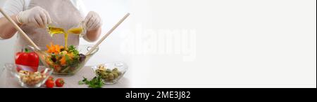 Leere weiße Räume Kochfrau Nahaufnahme in weißen Handschuhen Schürzen schütten Salat aus Glasgefäßen Olivenöl caesar Salat Dressing Gemüsesalat Banner Lebensmittelgeschäft Kochshow Werbetafeln Leute Stockfoto