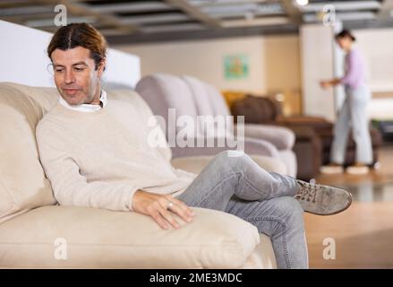 Der Mann überprüft die hohe Qualität des Sofas Stockfoto