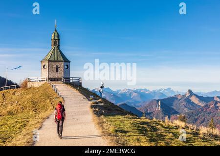 Deutschland, Bayern, Wanderer in Richtung Heilig Kreuz Kapelle auf dem Wallberggipfel Stockfoto