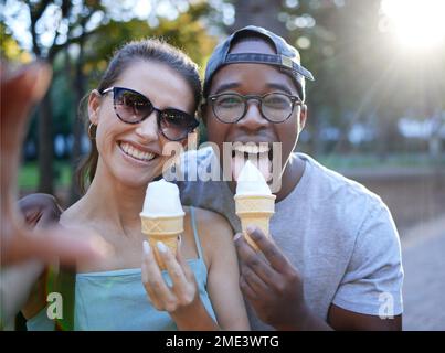 Liebe, Eis oder ein Paar machen ein Selfie in einem Park zu einem romantischen Date in der Natur in einer gemischtrassigen Ehe. Bilder, schwarzer Mann oder glückliche Frau beim Essen Stockfoto