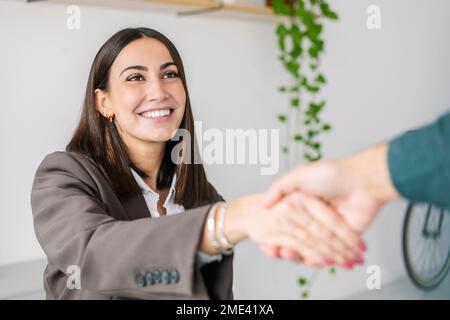 Glücklicher Anwerber, der dem Kandidaten im Amt die Hand schüttelt Stockfoto