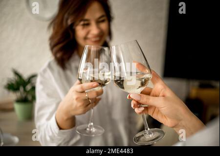 Glückliche Freunde, die zu Hause Gläser toasten Stockfoto