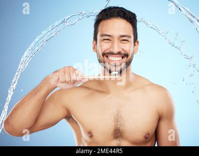 Wasserspritzer, Porträt oder Zahnbürsten im Studio mit Zahnbürste für weiße Zähne oder Zahnpflege. Gesicht, Bambusholz oder glückliche Person Stockfoto