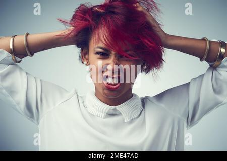 Ich brauche eine Pause von meinen Gedanken. Studioaufnahme einer schönen jungen Frau vor grauem Hintergrund. Stockfoto