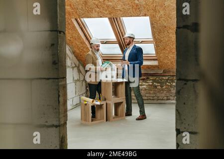 Architekten diskutieren über Hausmodell auf der Baustelle Stockfoto