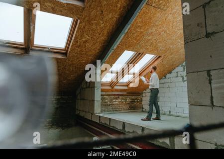 Architekt prüft Bauplan auf Baustelle Stockfoto