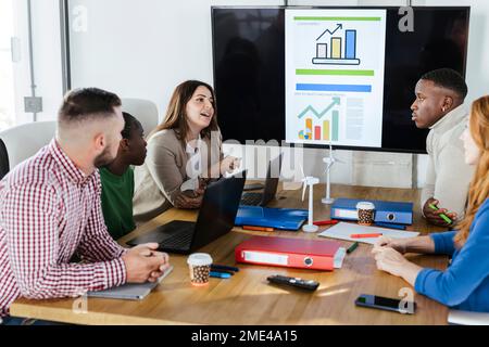 Geschäftsfrau, die mit Kollegen über erneuerbare Energien diskutiert, bei einem Meeting im Büro Stockfoto