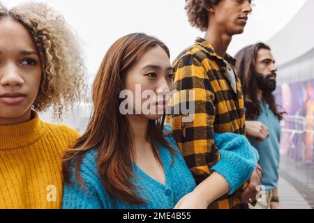 Selbstbewusste junge Frau im Pullover mit verschiedenen Aktivisten Stockfoto