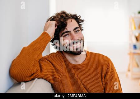 Glücklich Jüngling sitzt zu Hause auf sofa Stockfoto
