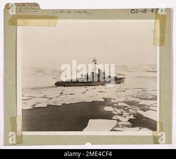 Das NORTHWIND Breaking Ice der Bucht der Wale. Die Antarktis. Während der Byrd-Expedition in die Antarktis hat der Eisbrecher der Küstenwache NORTHWIND Passagen für die begleitenden Dünnhüllenschiffe freigegeben. Hier arbeitet der NORTHWIND hart in der Bucht der Wale, an der äußeren Extremität des Ross Ice Shelf, im Hintergrund zu sehen. Das Eis in der Bay of Whales hatte eine durchschnittliche Dicke von 12 Metern. Stockfoto