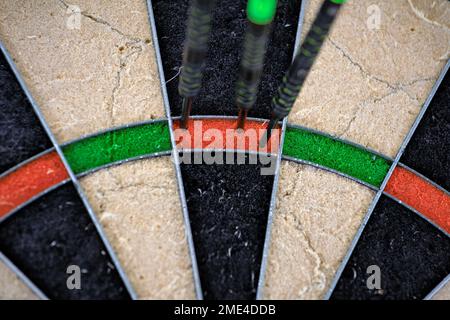 Drei Pfeile stecken in der Triple 20 einer Dartscheibe. 180 Punkte. Nahaufnahme einer Dartscheibe. Stockfoto