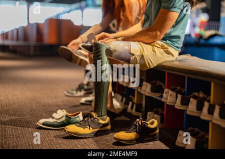 Ein Mann mit Beinprothese, der Bowlingschuhe in der Gasse trägt Stockfoto