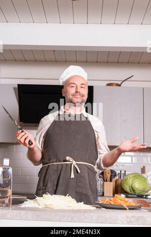 Porträt eines Mannes, der Küchenkleidung in der Küche zu Hause trägt Stockfoto
