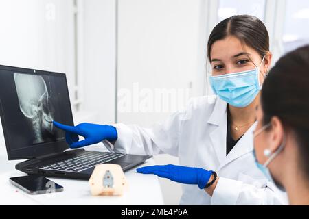 Zahnärzte diskutieren über das Röntgenbild auf dem Laptop Stockfoto