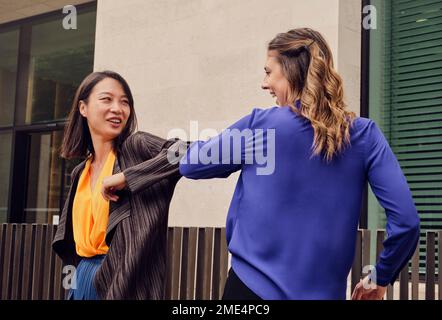 Glückliche Geschäftsfrau, die mit einem Kollegen zusammenstößt Stockfoto