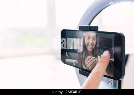 Junger Influencer, der einen Vlog aufnimmt, gesehen auf dem Smartphone Stockfoto