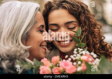 Glückliche Seniorin, die Enkelin umarmt Stockfoto