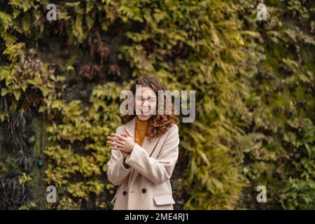 Fröhliche junge Frau, die im Park steht Stockfoto