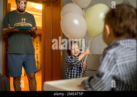 Glückliche Familie, die den Geburtstag des Jungen zu Hause feiert Stockfoto